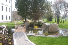 Teich mit Quellstein und Holzbrücke